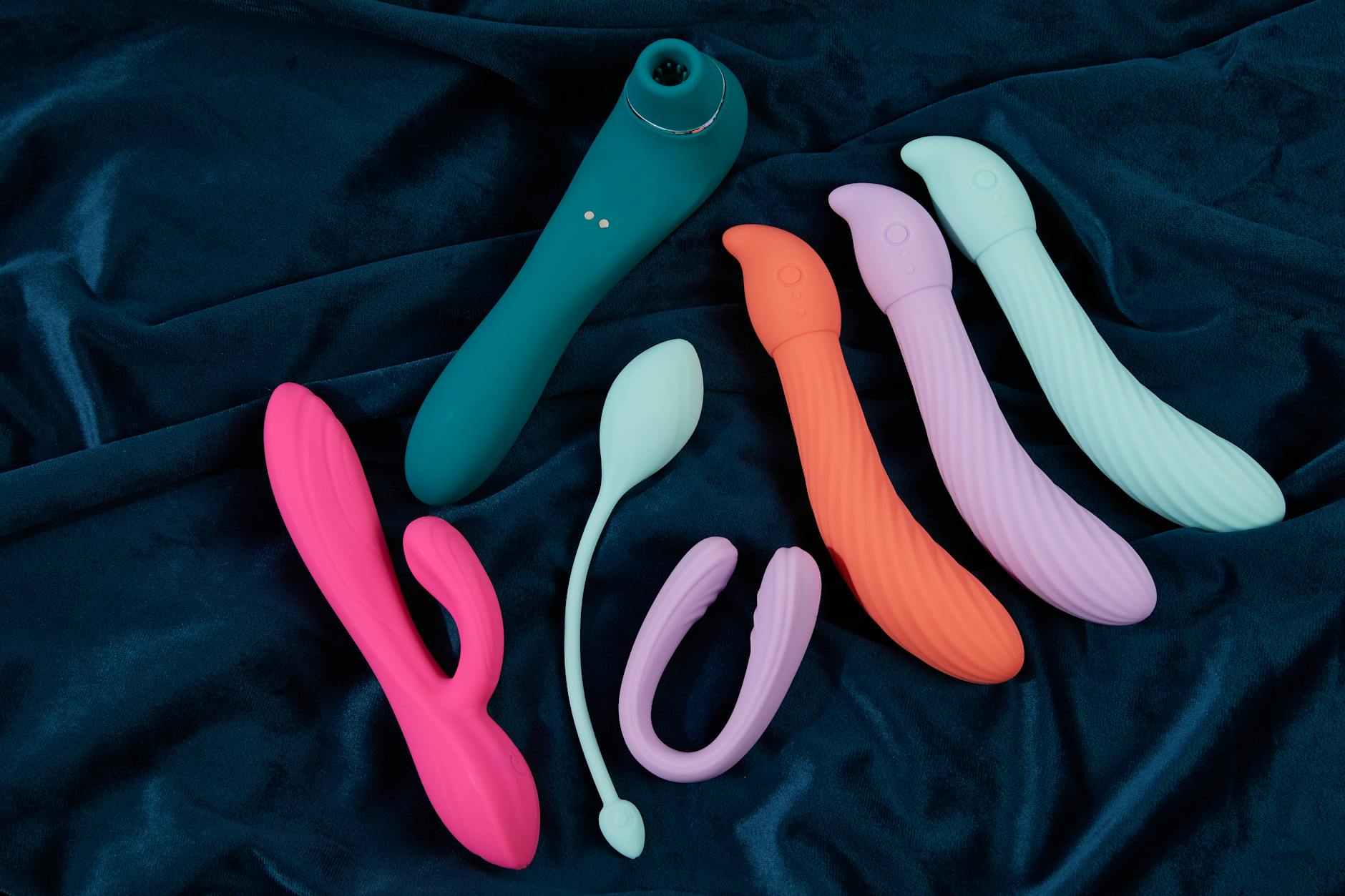 Mujer sosteniendo vibradores de colores, explorando nuevas sensaciones de placer