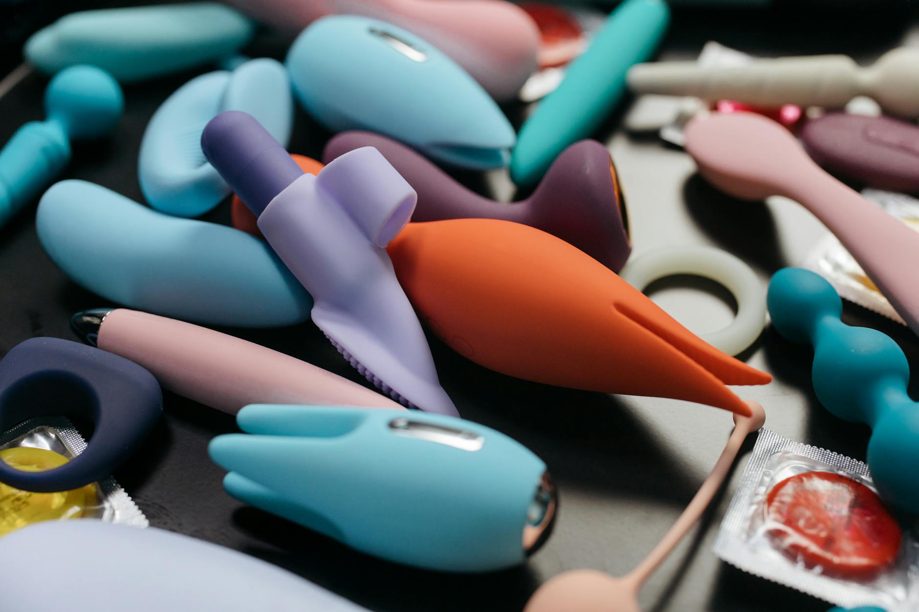 A hand holding a blue silicone vibrator against a purple background, symbolizing self-care and solo pleasure