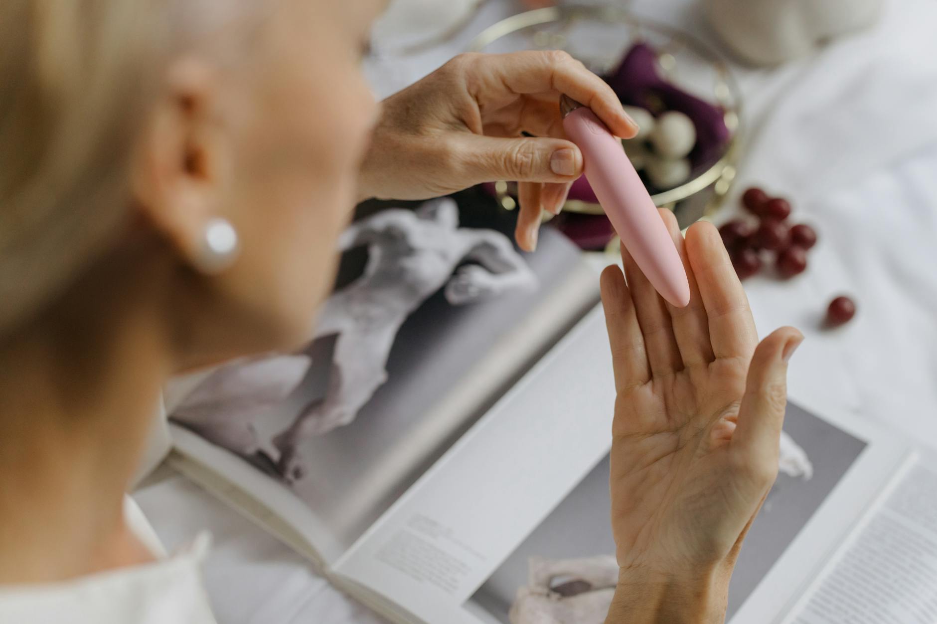 Woman holding a pink vibrator, illustrating intimate pleasure and body-centered self-care