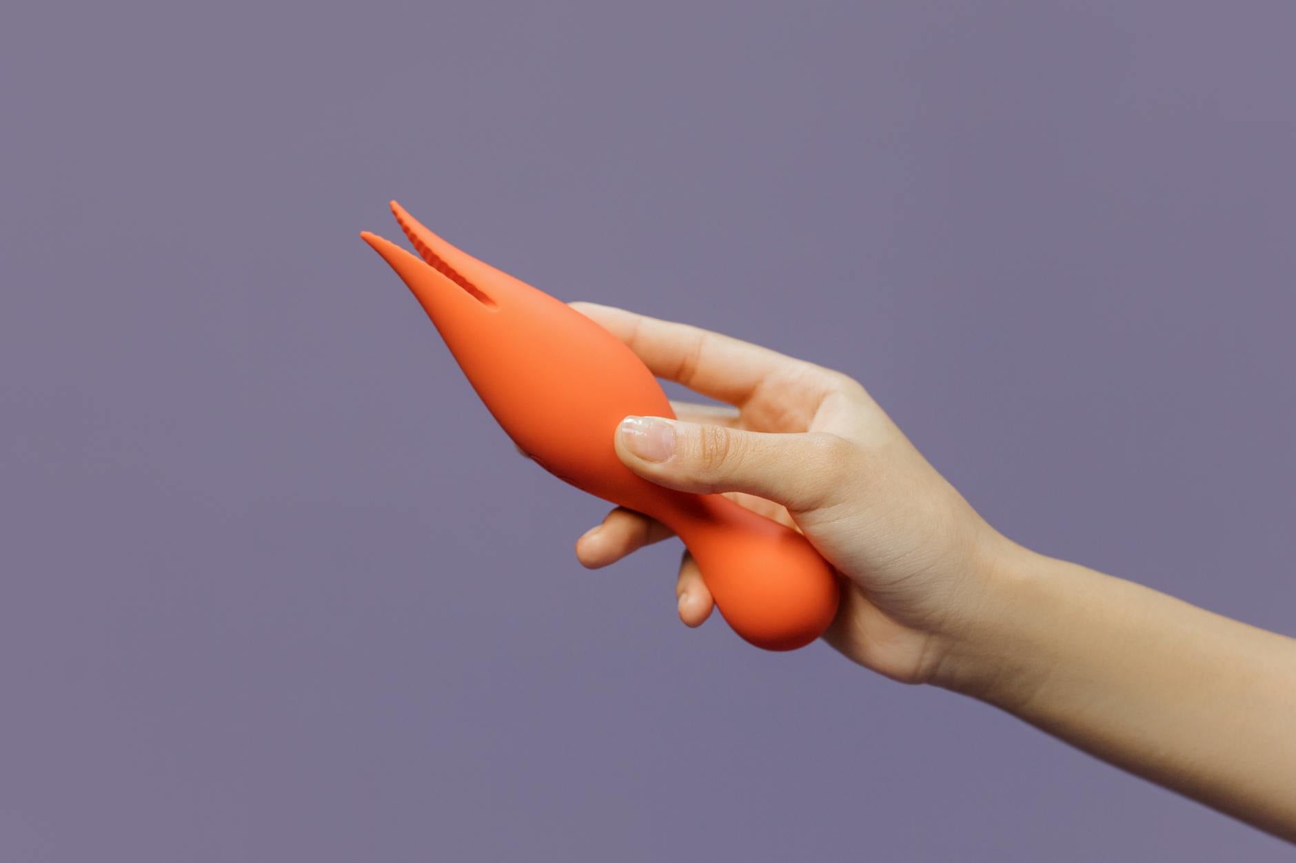 Mano sosteniendo un vibrador moderno contra un fondo morado minimalista, mostrando la sensualidad contemporánea.