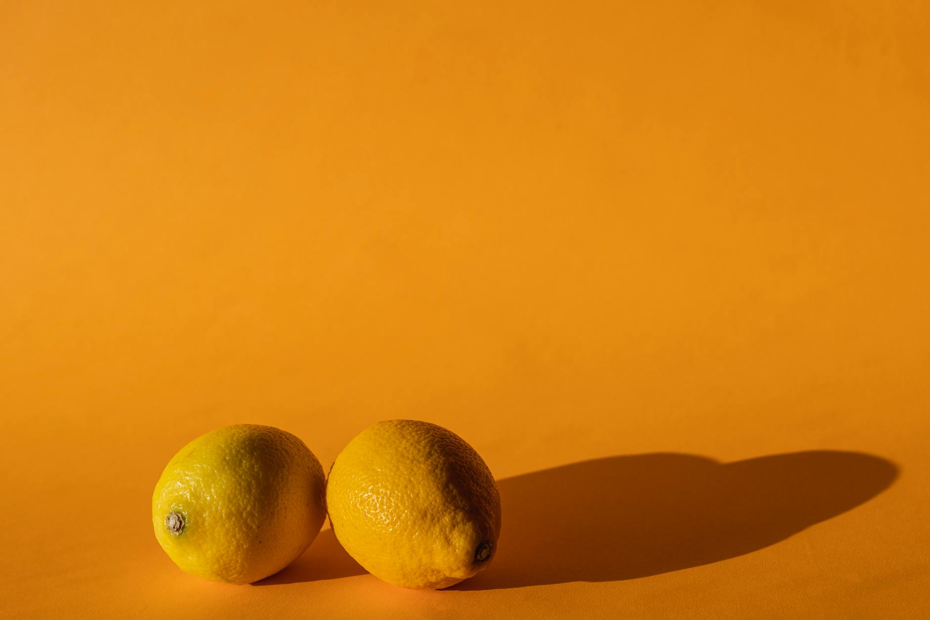 Fresh yellow lemons on a bright yellow background, symbolizing simplicity and natural pleasure